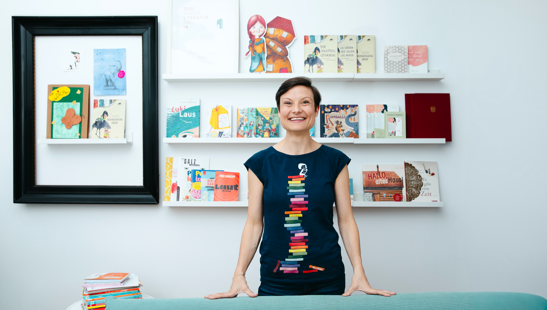 Lena Raubaum steht lächelnd vor einer Bücherwand
